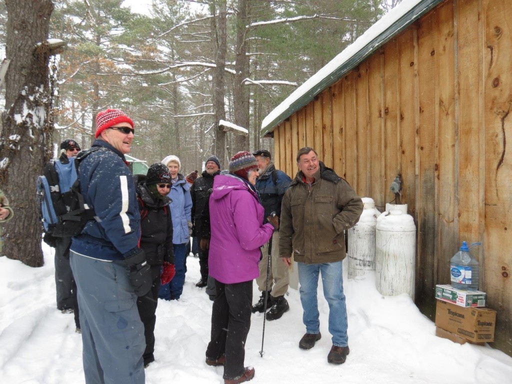 Gerry Lee, (far right) noted local conservationist, greets the MVFN group at his camp in the Pakenham highlands and explains the setting. Photo by Howard Robinson 